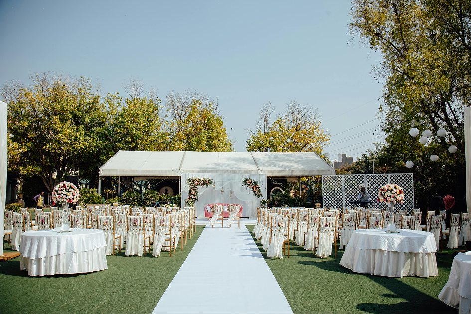 Outdoor wedding ceremony aisle leading to a white tent